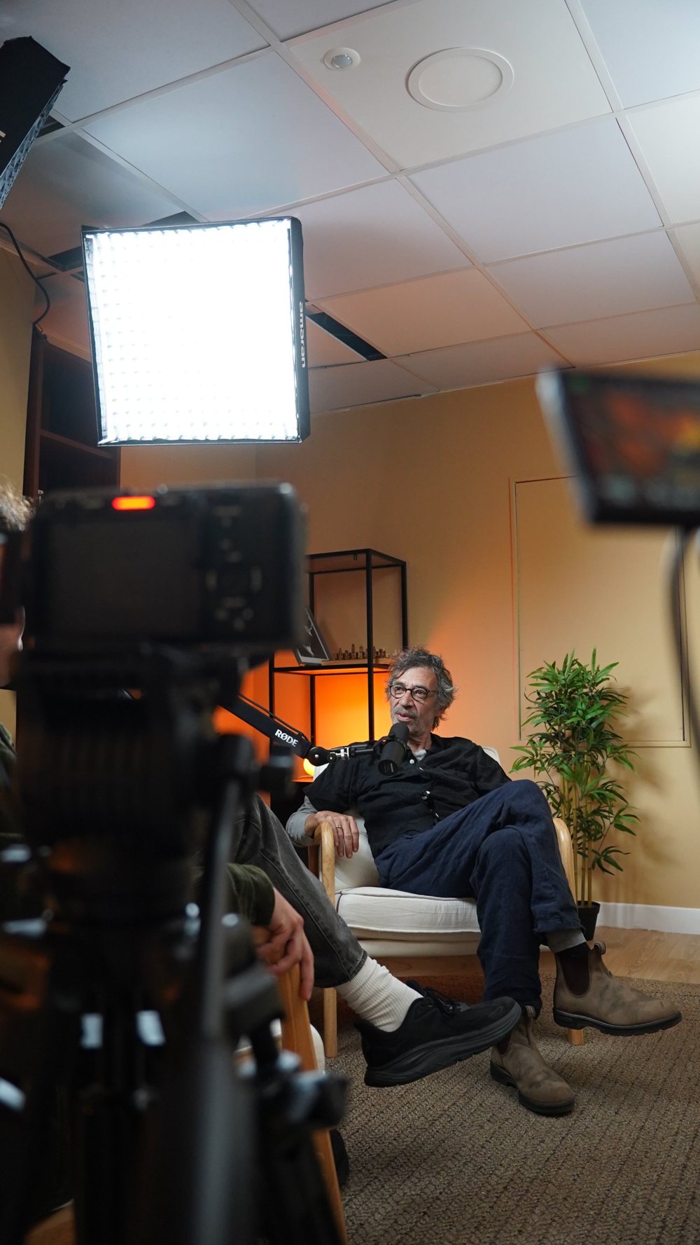 Un invite du podcast ACT en interview dans le studio podcast, entre projecteur et cameras